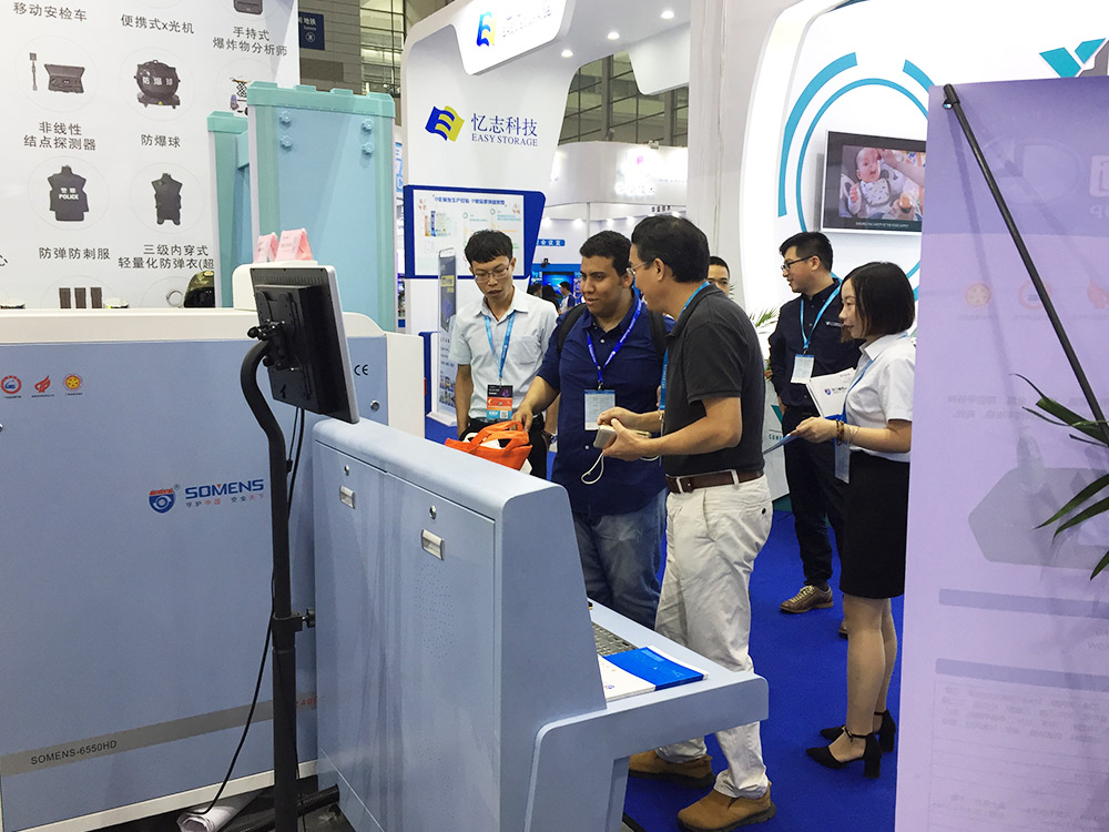 我司參展工作人員（yuán）為觀展者（zhě）介（jiè）紹安檢機安檢門