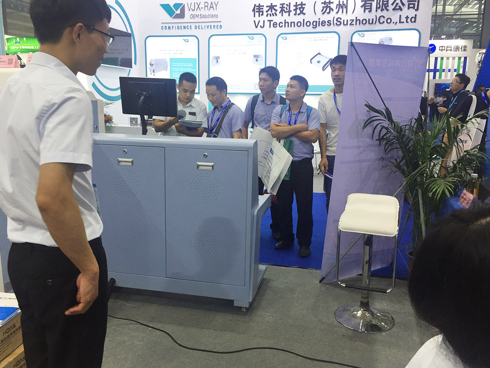 我司參（cān）展工作人員為觀展者介紹安（ān）檢機安檢門